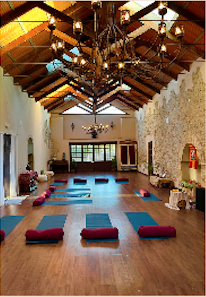 Meditation and practice room at Cortijo San Jose with yoga mats, bolsters and iron chandelier